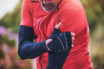 Image showing Man, cyclist and arm injury in sports accident, emergency or broken bone on mountain road in nature. Closeup of male person or athlete with sore pain, ache or joint inflammation from cycling or fall