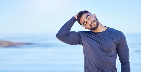 Image showing Beach, exercise and man stretching neck for outdoor freedom, sports workout or advertising space. Blue sky mockup, ocean water and Indian person start relax training warm up, challenge or muscle care