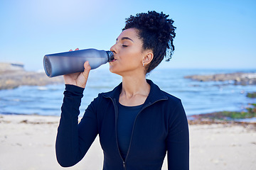 Image showing Woman, fitness and drinking water by ocean for training, exercise and workout nutrition, health or wellness outdoor. Tired runner or african person with liquid bottle for energy, sports and cardio