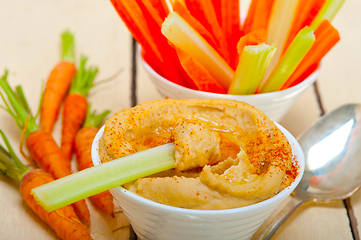 Image showing fresh hummus dip with raw carrot and celery