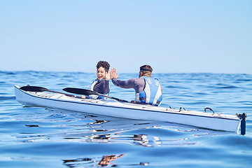 Image showing Water, man and woman in kayak with high five on lake, beach or river in sports challenge on vacation. Ocean holiday, adventure and fitness, happy couple in canoe for training success and winning race