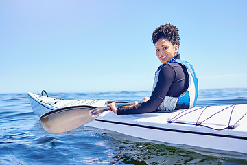 Image showing Water, sports and portrait woman in kayak at lake, beach or river for exercise, race or challenge. Ocean holiday, adventure and fitness, happy girl in canoe for training workout or fun competition.