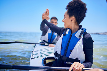 Image showing Water, high five with man and woman in kayak winning at lake, beach or river race for exercise challenge. Ocean holiday, adventure and fitness, happy couple celebrate in canoe for achievement at sea.