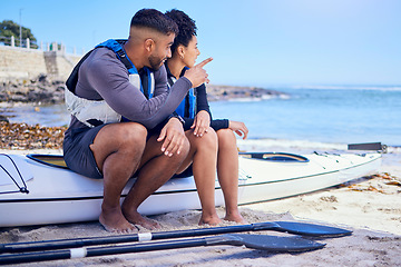 Image showing Couple, talking and outdoor for kayak or travel at a beach with a partner for teamwork. A man and woman with a canoe for sports, water adventure and vacation or freedom pointing at space in nature