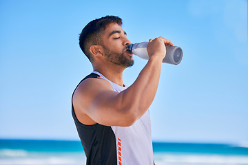 Image showing Man, fitness and drinking water on beach in hydration after workout, training or outdoor exercise. Thirsty or sporty male person in healthy diet, natural nutrition or mineral in sustainability by sea