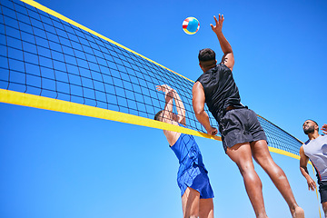 Image showing Beach volleyball match, blue sky and sports team jump, playing competition and practice for tournament challenge. Below view, athlete action and people in air workout, training or nature exercise