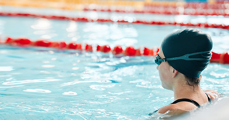 Image showing Woman, pool and swimming in water at start for sports fitness, race or training and practice. Active female person, athlete or professional swimmer getting ready for lap, workout or indoor exercise