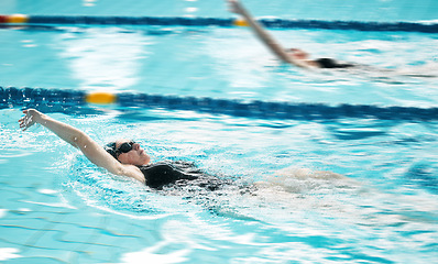 Image showing Sports, swimmer or people training in swimming pool for a race competition, exercise or cardio workout. Women, backstroke or athletes with energy or speed in fitness practice challenge for wellness