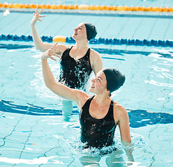Image showing Synchronized, swimming and women in competition performance, event or dance together in pool, water or sport. Athlete, swimmer and people training for concert, dancing or duet or stretching arms