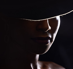 Image showing Woman, dark studio and hat for fashion, beauty and mystery with style, design or closeup headshot. Girl, model and black background for fantasy, night aesthetic or makeup for edgy, sexy woman and art