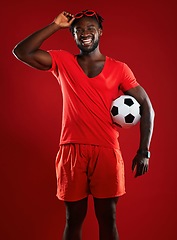 Image showing Black man, soccer ball and football in studio with happiness and red clothes with sunglasses and a positive mindset for sports. Portrait of a male from France happy and laughing in summer fashion