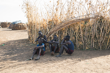 Image showing Dasanesh woman resting in shadow of hut, Omorate, Omo Valley, Ethiopia