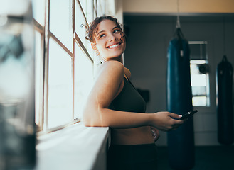 Image showing Window, smartphone and woman in gym, smile and online for training schedule, motivation and achievement. Happy, female athlete and girl with cellphone, break and connection for website and wellness