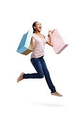 Image showing Success, fashion and woman jump with shopping bags in studio isolated on white background mock up. Discount celebration, sales deals and happy female customer jumping with gifts after buying at mall