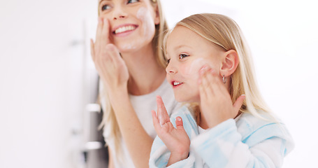 Image showing Skincare, mother and daughter home spa day washing their face in bathroom or apply beauty product, lotion or face mask while bonding at home. Happy woman and girl child doing morning skin routine