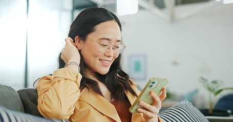 Image showing Phone communication, talking and asian woman at home on a sofa with a online conversation. Phone call, speaking and networking of a person on a mobile phone at a living room house on a couch