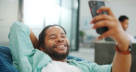 Image showing Black man, phone and peace sign on video call with smile for social, networking or communication at the office. African American man relaxing on break talking on smartphone videocall at the workplace