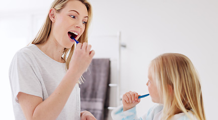 Image showing Toothbrush, mother and girl cleaning their teeth in the morning in the bathroom of their family home. Happy, bond and mom doing a dental hygiene routine for health with oral products with her child.
