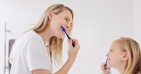 Image showing Toothbrush, mother and girl cleaning their teeth in the morning in the bathroom of their family home. Happy, bond and mom doing a dental hygiene routine for health with oral products with her child.