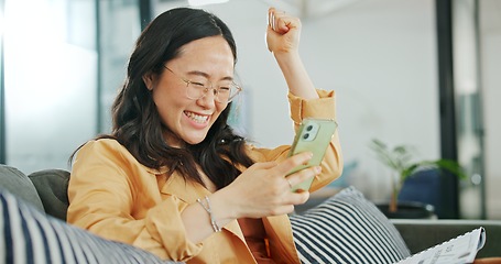 Image showing Business woman, phone or success fist on working office sofa, digital marketing startup or Asian advertising company. Smile, happy or winner creative designer on mobile technology or cheering goals