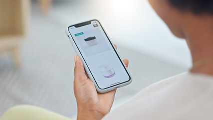 Image showing Shopping online and scrolling through makeup products to find a sale or discount. Hands of a woman browsing cosmetics on her phone from above. Enjoying the convenience and ease of purchasing apps