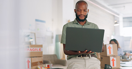 Image showing Laptop, creative and online order with a black man designer working in a workshop for shipping or delivery. Computer, ecommerce and logistics with a male managing stock or the shipment of goods