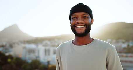 Image showing Face, happy and street style with a black man outdoor in the city with nature in the background during summer. Portrait, fashion and urban with a handsome young male standing outside in a bright town