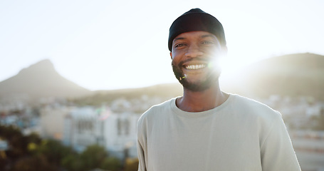 Image showing Face, happy and street style with a black man outdoor in the city with nature in the background during summer. Portrait, fashion and urban with a handsome young male standing outside in a bright town