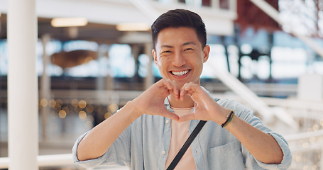 Image showing Shopping, hands in heart and face of Asian man with smile for shopping, retail and consumerism. Lifestyle, commerce and male enjoying weekend at shopping mall in Tokyo for sale, discount and bargain