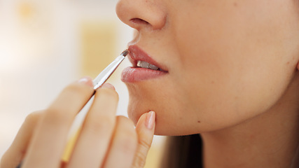 Image showing Painting young woman with pink lipstick on her mouth with brush, makes a kissing movement with lips and with a smile of excitement. Beauty products, cosmetics and makeup are part of female self care
