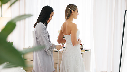 Image showing Happy bride in wedding dress, friends helping with knot on luxury corset back string and young women together in home. Asian woman supporting hug, marriage ready preparation and bridesmaid happiness