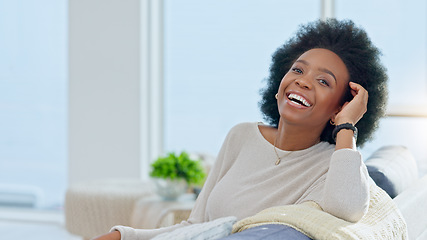 Image showing Portrait of a happy afro woman relaxing at home on the weekend. Beautiful casual African American female smiling and enjoying a relaxed Sunday afternoon in her bright living room with copy space