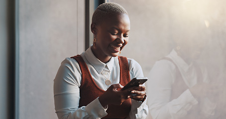 Image showing Happy, smile and face of a black woman on a phone while standing by the window in office. Technology, happiness and African female employee networking on social media or the internet on break at work