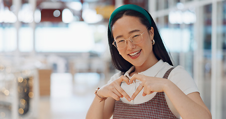 Image showing Happy woman, heart and love for creative fashion style in a office with a smile and happiness with hands for support of announcement. Portrait of asian employee with emoji sign for marketing project