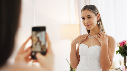 Image showing Wedding, ring and engagement with a woman or bride taking a photograph on a phone and drinking champagne with a friend. Happy, smile and celebration with an attractive young female and her bridesmaid