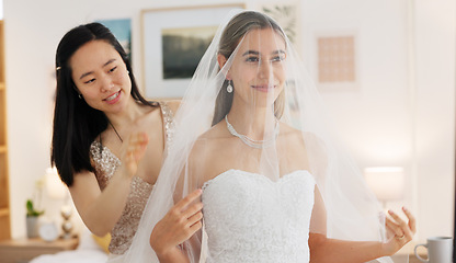 Image showing Bride, wedding and woman helping with veil in dressing room smile for special day. Happy women love and bridesmaid support or helping bride with fabric head piece for beauty, marriage and happiness