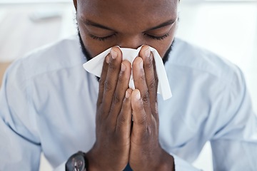 Image showing Black man, tissue and blowing nose in the office with allergies, sickness and virus. Business employee, face and corporate worker sick with a cold or allergy sneeze in the workplace with fever