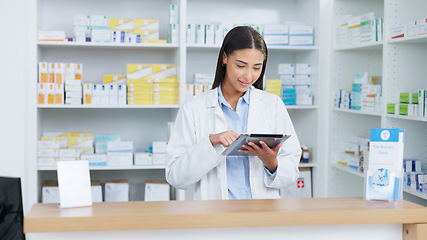 Image showing Portrait of a cheerful and friendly pharmacist using a digital tablet to check inventory or online orders in a chemist. Young latino woman using pharma app to do research on medication in a pharmacy