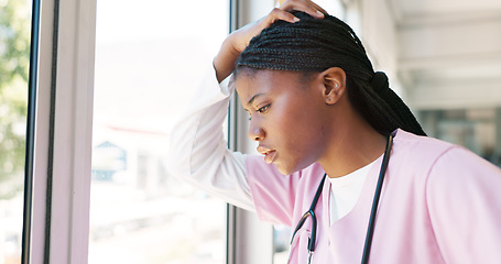 Image showing Nurse, stress thinking and hospital window for relax breathing, stress relief and healthcare worker frustrated or overworked. Black woman, employee burnout and anxiety headache working in clinic