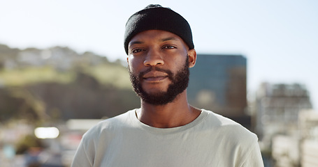 Image showing Face, confident and city with an edgy black man outdoor in an urban town for fashion or street style. Portrait, cityscape and lifestyle with a young African American male outside on a summer day