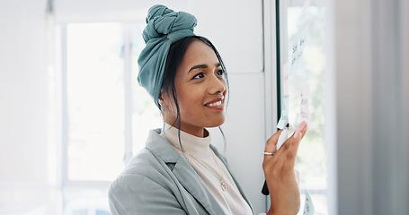 Image showing Business woman, writing and brainstorming idea with glass board and post it, happy with focus and planning strategy for project. Corporate employee, marketing strategy or project management goals.