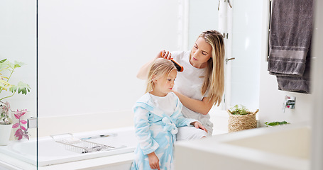 Image showing Morning, mother and daughter in bathroom with hair brush for grooming care routine in family home. Motherhood, child and mama brushing hair of young kid in house and getting ready for the day.