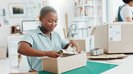 Image showing Startup, shop and entrepreneur packing a box for an order of products for shipment or delivery. Black business owner preparing a retail package for courier with her corporate partner in their office.