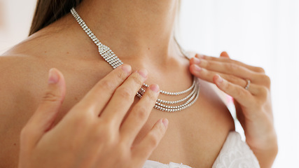 Image showing Bride, jewelry and diamond necklace on a woman getting ready for her wedding day and touching her bridal jewelry while standing inside. Closeup neck of rich female wearing white dress and shiny bling