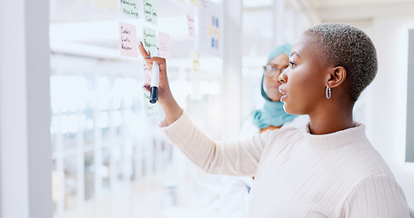 Image showing Teamwork, business people and leadership of black woman with sticky note in office workplace. Coaching, collaboration and female employees brainstorming sales or marketing strategy on glass wall.