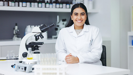 Image showing Portrait of a female scientist using a microscope in a research lab. Young biologist or biotechnology researcher working and analyzing microscopic samples with the latest laboratory tech equipment