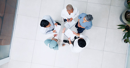 Image showing Top view, business and team in lobby, brainstorming and planning for marketing development, sales growth and office. Teamwork, innovation and staff share ideas, conversation and project collaboration