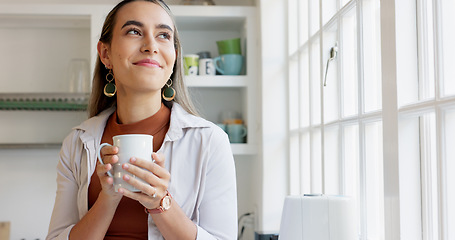 Image showing Beautiful woman looking out window holding cup of coffee