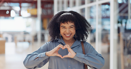 Image showing Hands, heart and love with a business black woman making a hand gesture alone in her office at work. Happy, smile and positive with a female employee gesturing a hand sign for romance or affection