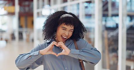 Image showing Hands, heart and love with a business black woman making a hand gesture alone in her office at work. Happy, smile and positive with a female employee gesturing a hand sign for romance or affection